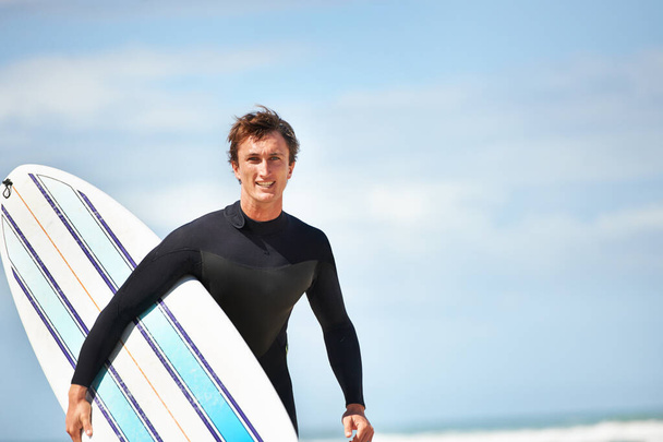 To tylko ja i deska surfingowa. Portret młodego surfera na plaży w słoneczny dzień. - Zdjęcie, obraz