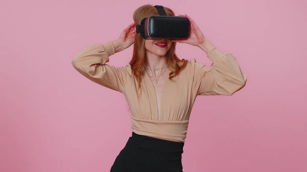 Dziewczyna wykorzystująca futurystyczną technologię wirtualnej rzeczywistości kask VR do symulacji gry wideo 3D - Zdjęcie, obraz