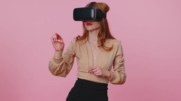 Κορίτσι που χρησιμοποιεί φουτουριστική τεχνολογία εικονικής πραγματικότητας κράνος σετ κεφαλής VR για να παίξει προσομοίωση 3D βιντεοπαιχνίδι - Φωτογραφία, εικόνα