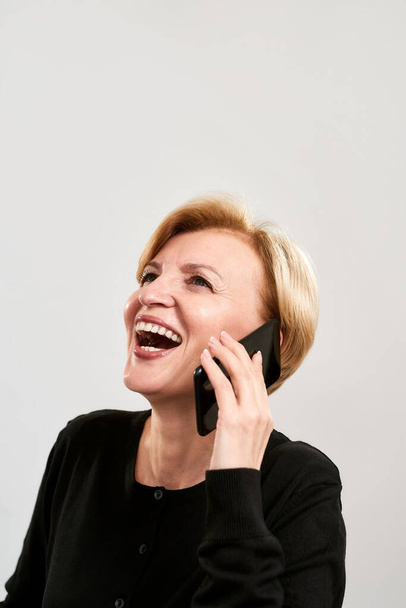 Cheerful middle aged woman talking on smartphone - Fotoğraf, Görsel