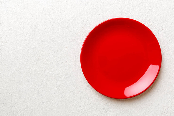 Top view of empty red plate on cement background. Empty space for your design. - Φωτογραφία, εικόνα