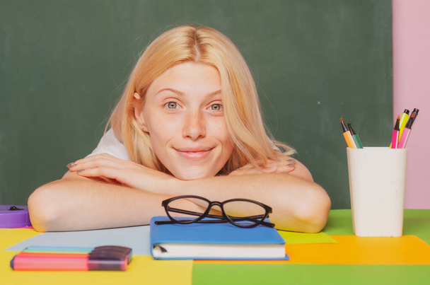 Modern attractive teacher face. Portrait of smart young teacher with book in class at school. Study concept. - 写真・画像