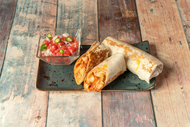 A tinga egy mexikói étel, aprított hússal, paradicsomon, hagymán, fokhagymán és chipotle chilin alapuló szószban. Általában pirítóssal, tacóval, quesadillával vagy molottal fogyasztják, avokádóval kísérve. - Fotó, kép