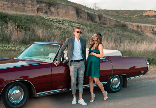 Mode Schwangere mit geliebtem Mann stehen neben rotem Auto - Foto, Bild