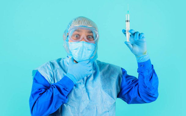 Doctor in protective suit, glasses and medical mask with syringe preparing for injection. Vaccination. - Foto, Imagen