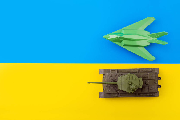 Askeri savaş uçağı, savaş uçağı ve Ukrayna bayrağının arka planında tank. Ukrayna halkının Rusya 'yla savaşa katılma kavramı. Savaş konsepti değil. Savaşı bitirmek, barışa gitmek - Fotoğraf, Görsel