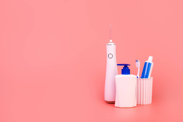 Zusammensetzung mit manueller Zahnbürste, Bewässerungssystem, Zahnpasta, Mundhygieneprodukten und Seife auf farbigem Hintergrund. Mundpflege-Konzept. Hygienekonzept - Foto, Bild