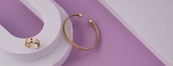 Panorama of Modern geometric bracelet and ring on white round podium and triangle copy space - Photo, Image