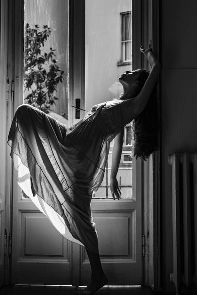 Woman meets morning near balcony. Relax time. Young woman standing near window. Erotic nightie. Passion and temptation. She happy dances. - Foto, Bild