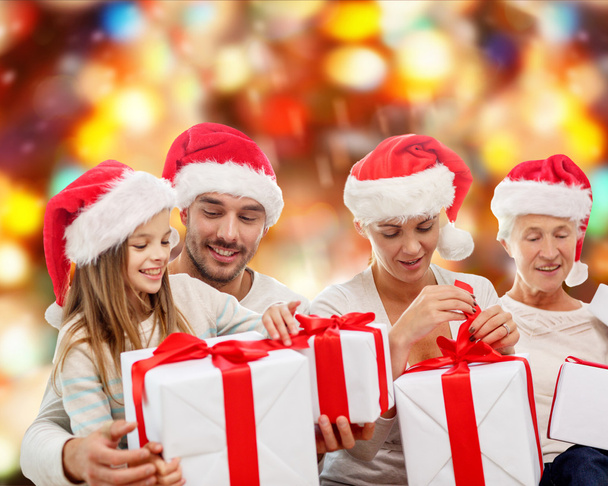 happy family in santa helper hats with gift boxes - Zdjęcie, obraz