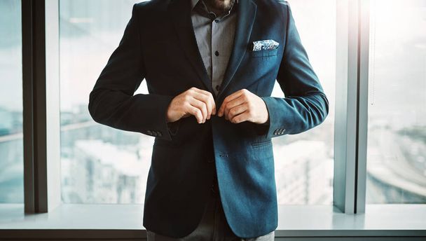 Успех стал реальным. Обрезанный снимок стильной пуговицы бизнесмена его куртки в современном офисе. - Фото, изображение