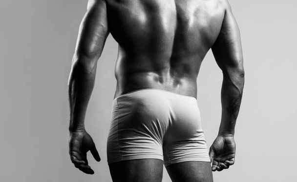 Man buttocks in yellow underpants. Muscular man with muscular buttocks. Bare nude torso, Naked male ass. - Foto, immagini