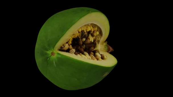 Rendimiento realista de un corte giratorio Papaya verde (inmadura) sobre fondo negro. El video está girando sin problemas, y el objeto 3D se escanea desde una papaya real. - Imágenes, Vídeo