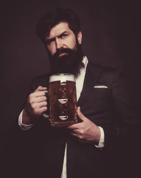 Happy elegant man drinking beer. Senior man in black suit drinking beer with surprise face. - Фото, зображення