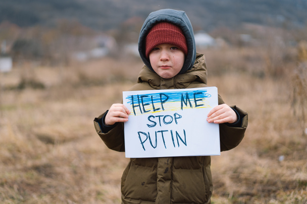 ロシアとウクライナの戦争。泣いている少年はウクライナでの戦争を止めるように頼む. - 写真・画像