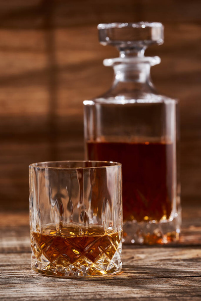 Bourbon or scotch in a classy decanter and a beautiful glass on a wooden board - Foto, Imagem