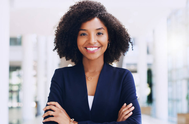 I am proud of how far I have come. Cropped portrait of an attractive young businesswoman smiling and standing in the office with her arms crossed during the day. - Zdjęcie, obraz