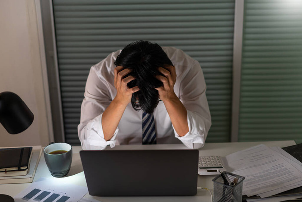 Koncept přepracování Muž, který dnes pracuje v kanceláři a drží si hlavu kvůli stresu z práce. - Fotografie, Obrázek