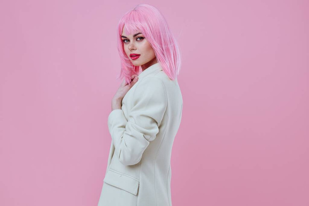 Hübsche junge Frau in einem Anzug Make-up rosa Haare posiert Farbe Hintergrund unverändert - Foto, Bild