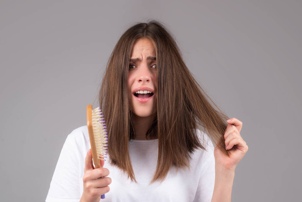 Hair care. Girl with straight brushed hair. Hair tangling problem. Unhappy girl with tangled hair. Damaged hairloss combing. - Foto, Imagen