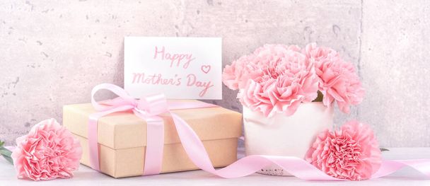 May mothers day handmade giftbox wishes photography - Beautiful blooming carnations with pink ribbon box isolated on fair-faced gray background desk, close up, copy space, mock up - Photo, image