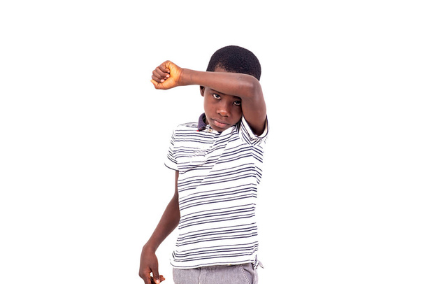 jovem menino em t-shirt de pé no fundo branco posando com braço na testa olhando triste. - Foto, Imagem