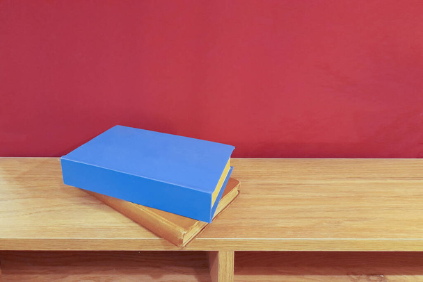 libri in piedi sul pavimento in legno davanti alla parete rossa - Foto, immagini