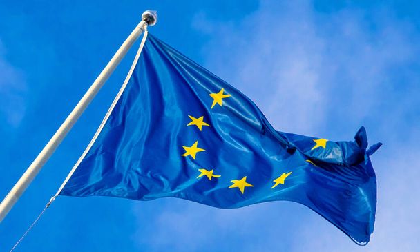 Die Flagge der Europäischen Union weht im Wind vor blauem Himmel - Foto, Bild