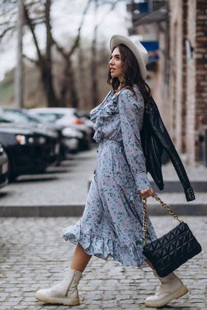 Kaunis nuori nainen hatussa ja sininen mekko kävelee kaupungin läpi. kävely, ostokset. - Valokuva, kuva