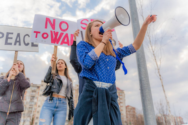Grupo de personas hermosas y tristes están protestando en voz alta juntos en la calle mientras gritan, bajo ángulo - Foto, Imagen