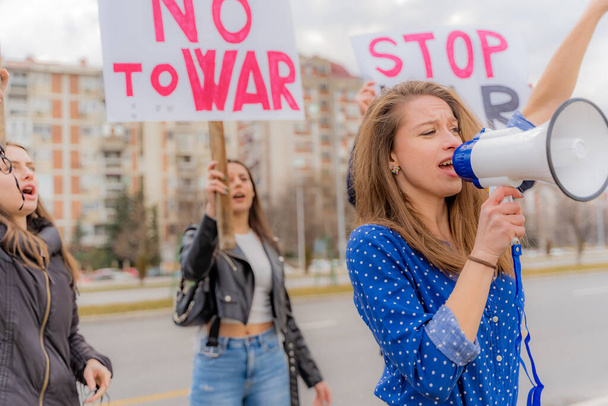 Όμορφη και λυπημένη κοπέλα έχει μια ομιλία, ενώ διαμαρτύρεται με τους υποστηρικτές της - Φωτογραφία, εικόνα