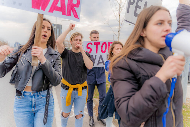 Grupo de jóvenes protestan y caminan mientras gritan juntos - Foto, Imagen