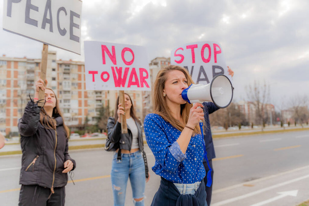 Mooi en verdrietig meisje houdt een toespraak over de oorlog op de megafoon - Foto, afbeelding