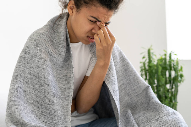 Väsynyt afroamerikkalainen tyttö hieromassa nenäänsä ja silmiään. Kärsi flunssasta. Huonovointisuus. Kivulias ilme. Lääkkeen käsite - Valokuva, kuva