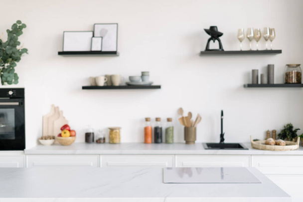 Eigentijdse Scandinavische keuken interieur met inductie kookplaat. Stijlvol keukengerei en decor. Thuis comfort en gezelligheid. Appartement met witte tinten - Foto, afbeelding