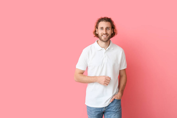 Handsome young man in stylish polo shirt on pink background - Photo, Image