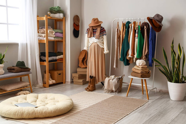 Interior of light dressing room with mannequin, rack and warm sweaters - Foto, imagen