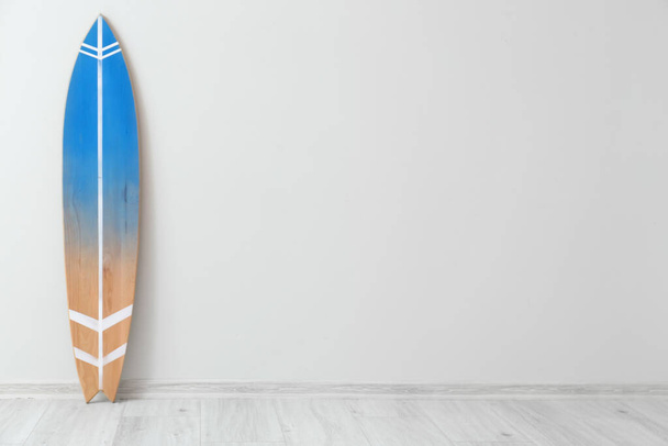 Tavola da surf in legno vicino alla parete luminosa - Foto, immagini