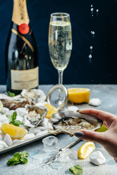 Fresh oysters with lemon and ice. Restaurant delicacy. oysters dish. Oyster dinner with champagne in restaurant, banner, menu, recipe place for text, top view, - Φωτογραφία, εικόνα