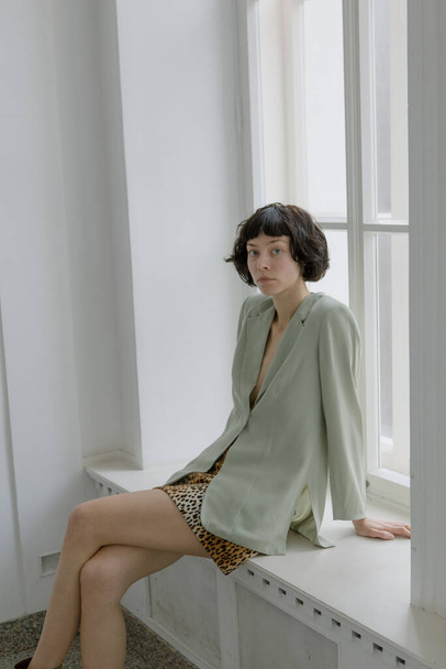 Stylish and cute girl in fashionable clothes in a minimalist interior - Valokuva, kuva