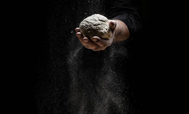 le chef saupoudre la farine à travers un tamis, farine poudreuse volante dans l'air. chef mains avec de la farine dans un mouvement de gel d'un nuage de farine midair. - Photo, image