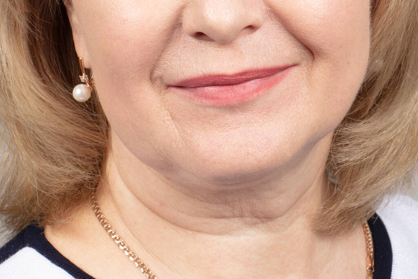 Половина обличчя зі зморшками літньої жінки. Зморшкуваті губи зрілої жінки. Ознаки старіння шкіри після 40 років
. - Фото, зображення