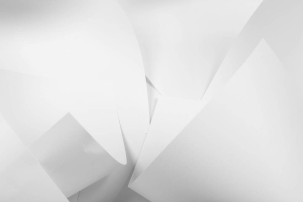 Białe kartki papieru biurowego są powykręcane i rozrzucane. Papier biały abstrakcyjne tło. - Zdjęcie, obraz