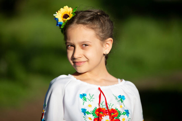 Pieni ukrainalainen ja valkovenäläinen tyttö kirjailtu paita kesätaustalla. - Valokuva, kuva
