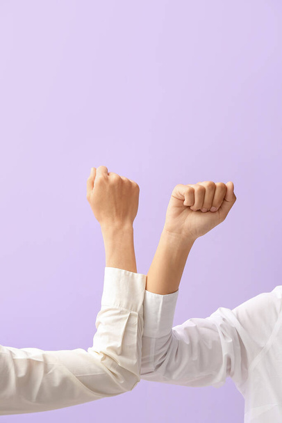 Руки бізнес-леді зі згорнутими кулаками на кольоровому фоні
 - Фото, зображення