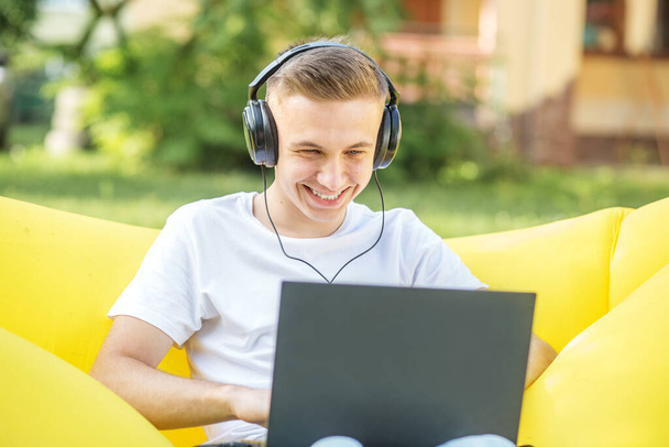 Fiatal srác kommunikál keresztül video chat fülhallgató és mosoly. - Fotó, kép
