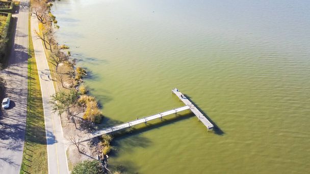 Beautiful lakeside park with long jetty boardwalk fishing dock and fishermen near Dallas, Texas, America. Aerial view outdoor and recreational activities in fall afternoon at urban park - Photo, Image