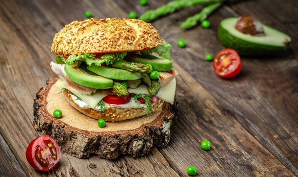 Delicious burgers with chicken fillet, asparagus, avocado, tomatoes, peas, cheese and tartar sauce. fast food and junk food concept. - Photo, Image