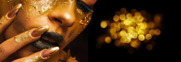 Beauty fashion model girl with golden make-up and body on black background. Golden body art. The golden face of a beautiful lady is touching. Artistic portrait. - Photo, image