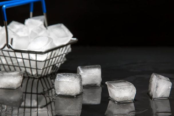замороженные кубики льда в корзине с продуктами на темном фоне - Фото, изображение
